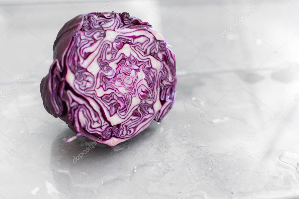 Fresh red cabbage. Close-up. Macro. On a light gray concrete background in water. Space for text