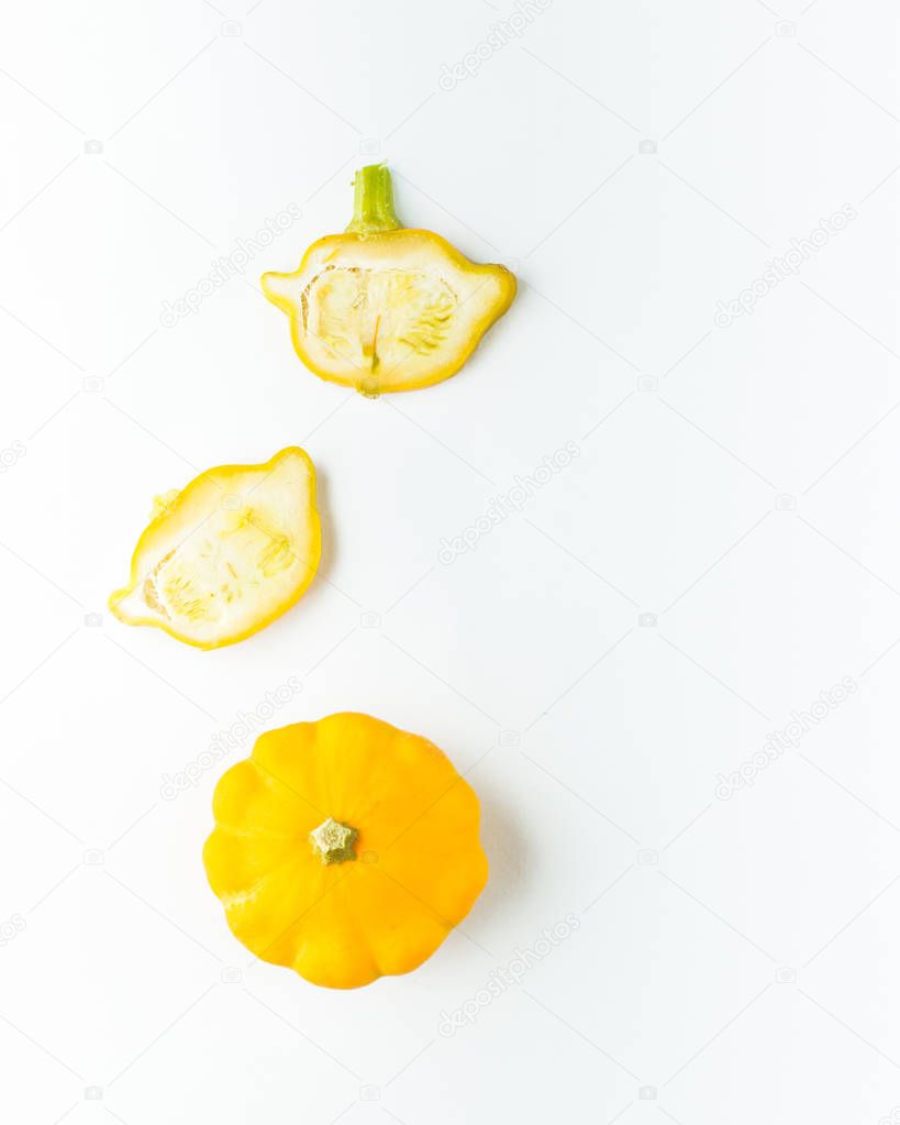 Creative layout (pattern) made of small yellow pumpkins. Flat lay. Food concept. Vegetables isolated on white background. Vegetables abstract background