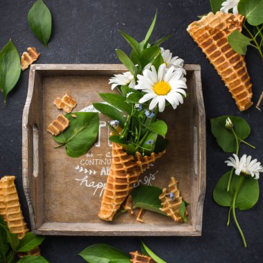 Dondurma külahı chamomiles siyah bir beton zemin üzerine buket. Taze çiçekler. kır çiçekleri güzel buket. Uzay kopyalayın. Metin için yer. Gıda Fotoğraf elleri olan. Düz yatıyordu, en iyi görünümü