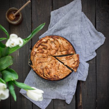 Ahşap arka plan üzerinde elma ile tam buğday unu ile ev yapımı kek. Elleriniz ve çiçekler gıda fotoğraf. Yararlı diyet pişirme. Düz yatıyordu, en iyi görünümü