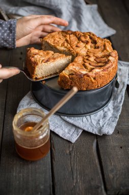 Ahşap arka plan üzerinde elma ile tam buğday unu ile ev yapımı kek. Elleriniz ve çiçekler gıda fotoğraf. Yararlı diyet pişirme.