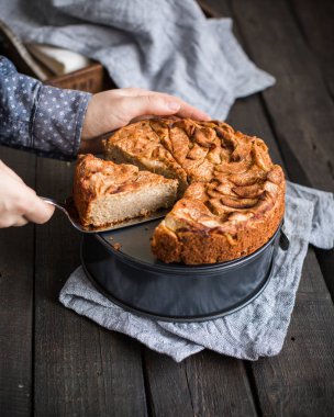 Ahşap arka plan üzerinde elma ile tam buğday unu ile ev yapımı kek. Elleriniz ve çiçekler gıda fotoğraf. Yararlı diyet pişirme.