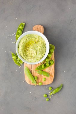 Nohut ve yeşil bezelye, zeytinyağı ve zeytin-ahşap panosunda baharat geleneksel klasik humus. Yararlı diyet çerez. 