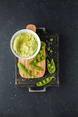 Nohut ve yeşil bezelye, zeytinyağı ve zeytin-ahşap panosunda baharat geleneksel klasik humus. Yararlı diyet çerez. 