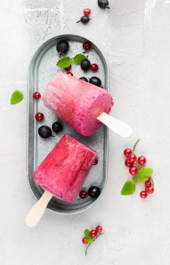 Berry smoothies bir ışık gri beton zemin üzerine taze kırmızı kuş üzümü ve metin için siyah gooseberry.place parlak kağıt bardak dondurulmuş. düz yatıyordu, en iyi görünümü