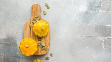 Küçük portakal squashes (kabak) tohumları ile beton açık renkli ahşap bir gemide üzerinde. 