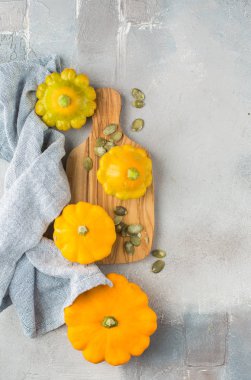 Küçük portakal squashes (kabak) tohumları ile beton açık renkli ahşap bir gemide üzerinde. 