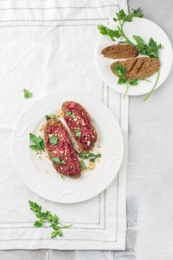 Bütün tahıl ekmeği pancar ile gelen ev yapımı ekmek hamur, Yeşiller ve fındık. Hafif beton arka plan, beyaz yumuşak. Metin için yer. Gıda Fotoğraf elleri olan. Yararlı diyet pişirme. Düz yatıyordu, en iyi görünümü