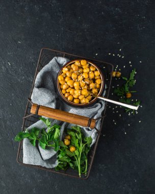 Baharatlar ve susam bir vintage içinde pişmiş nohut yeşil ve siyah bir beton zemin üzerine maydanoz ile metal sepet örgülü. Yararlı diyet çerez. Metin için yer. Düz yatıyordu, en iyi görünümü