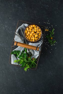 Baharatlar ve susam bir vintage içinde pişmiş nohut yeşil ve siyah bir beton zemin üzerine maydanoz ile metal sepet örgülü. Yararlı diyet çerez. Metin için yer. Düz yatıyordu, en iyi görünümü