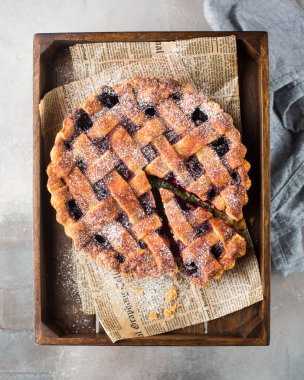 Amerikan vişneli tart, pudra şekeri gri beton zemin üzerine. Uzay kopyalayın. Metin için boş alan görüntüleyin. Metin için yer. Gıda fotoğraf. Düz yatıyordu, en iyi görünüm çok kolay mezarda. Zanaat gazete