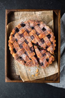 Amerikan vişneli tart, pudra şekeri gri beton zemin üzerine. Uzay kopyalayın. Metin için boş alan görüntüleyin. Metin için yer. Gıda fotoğraf. Düz yatıyordu, en iyi görünüm çok kolay mezarda. Zanaat gazete