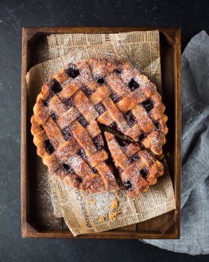 Amerikan vişneli tart, pudra şekeri gri beton zemin üzerine. Uzay kopyalayın. Metin için boş alan görüntüleyin. Metin için yer. Gıda fotoğraf. Düz yatıyordu, en iyi görünüm çok kolay mezarda. Zanaat gazete