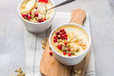 Klasik cheesecake taze kızılcık, fındık ve bal açık beton renkli ve ahşap tahta küçük seramik kavanozlarda ile. En lezzetli tatlı veya mükemmel sağlıklı kahvaltı!)