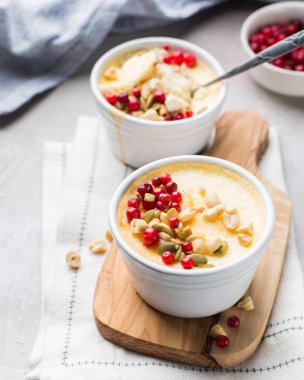 Klasik cheesecake taze kızılcık, fındık ve bal açık beton renkli ve ahşap tahta küçük seramik kavanozlarda ile. En lezzetli tatlı veya mükemmel sağlıklı kahvaltı!)