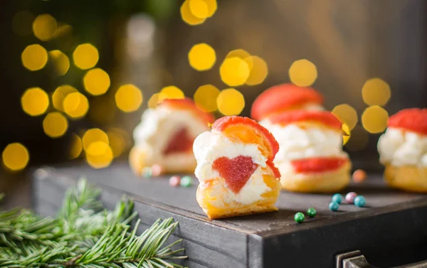Choux 蛋糕与乳酪奶油和草莓果冻心脏里面在黑暗的木背景与灯 完美的圣诞甜点最好的庆典背景 冬季圣诞节假期概念 — 图库照片
