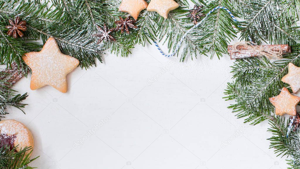 Ginger homemade cookies with strawberry jam on white wooden background with Christmas tree. Winter holidays concept. Flat lay, top view. Xmas Border - horizontal banner. Web size. 