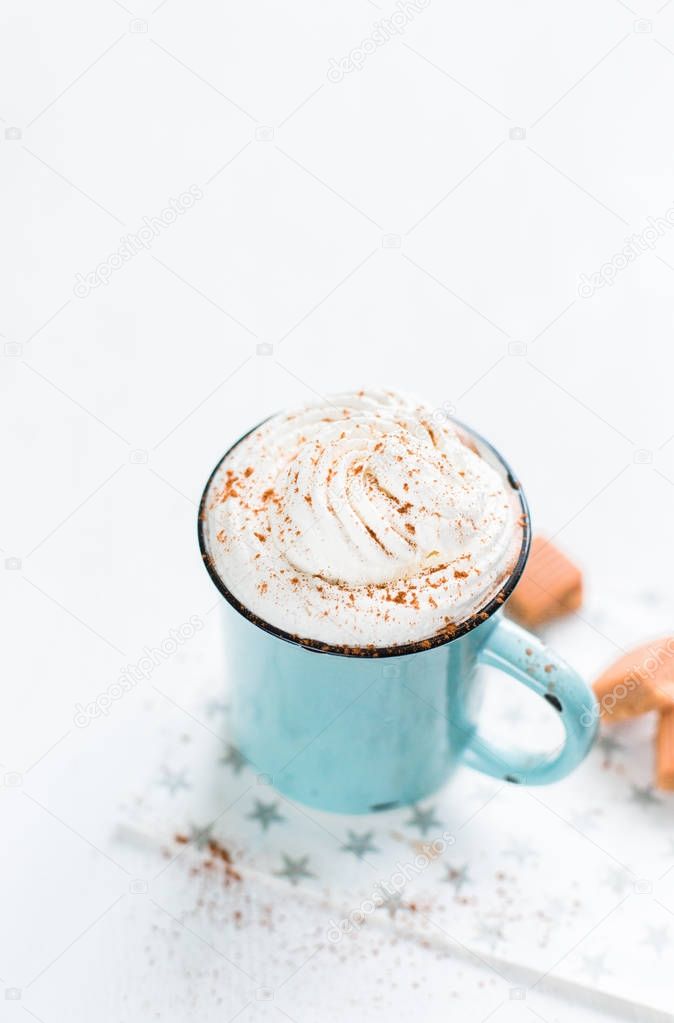 Christmas mood!) Hot chocolate with cream, cinnamon and a toffee in a blue vintage mug on a light background. The best celebration background. Winter xmas holidays concept.