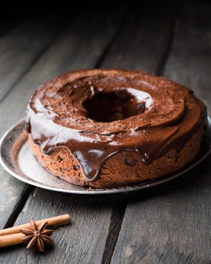 Çikolatalı kek ile fındık, kızılcık, çikolata ganache ve köknar ağacı ve baharat koyu ahşap zemin üzerine kakao tozu. Noel dekor tablo. Kış xmas tatil kavramı. Şenlikli ruh hali