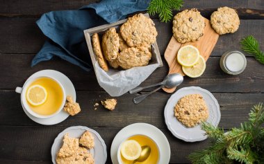 Mükemmel lezzetli breakfast. Yulaf ezmeli kurabiye kupalar Xmas ağacı ile karanlık bir arka plan üzerinde limon ile ahşap kutu ve yeşil çay çikolata ile. En iyi yararlı tanımlama bilgileri. Düz yatıyordu, en iyi görünümü