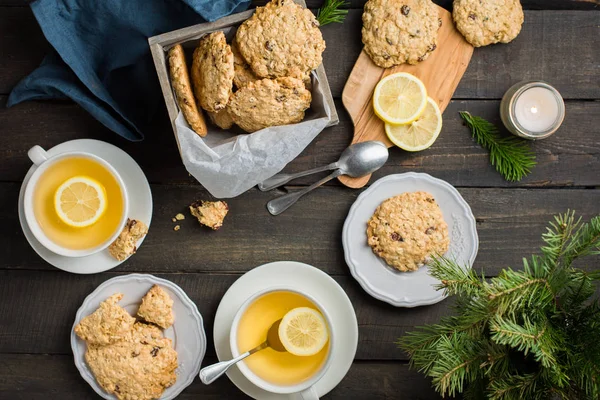 Mükemmel lezzetli breakfast. Yulaf ezmeli kurabiye kupalar Xmas ağacı ile karanlık bir arka plan üzerinde limon ile ahşap kutu ve yeşil çay çikolata ile. En iyi yararlı tanımlama bilgileri. Düz yatıyordu, en iyi görünümü