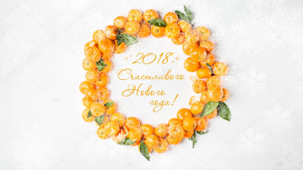 2018 Happy New Year! Christmas  tangerine mood!) Wreath made of  fresh small tangerines and green leaves on white wooden background. The best xmas celebration background.  Flat lay, top view