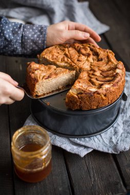 Ahşap arka plan üzerinde elma ile tam buğday unu ile ev yapımı kek. Elleriniz ve çiçekler gıda fotoğraf. Yararlı diyet pişirme. Düz yatıyordu, en iyi görünümü