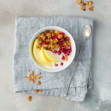 Sağlıklı kahvaltı. Nar, yeşil elma ve yoğurt beton zemin üzerine gözlük ile granola ile. Taze çilek, taze meyve, ev yapımı granola. Ülke stil. Rustik tarzı. Metin için yer