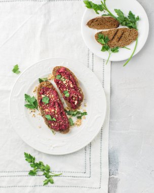 Bütün tahıl ekmeği pancar ile gelen ev yapımı ekmek hamur, Yeşiller ve fındık. Hafif beton arka plan, beyaz yumuşak. Metin için yer. Gıda Fotoğraf elleri olan. Yararlı diyet pişirme. Düz yatıyordu, en iyi görünümü
