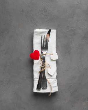 Sevgililer Günü (ya da düğün) yemek arkaplanı kırmızı kurdele, kalp, çatal, bıçak, beyaz tabak ve peçete. Romantik tatil sofrası. Güzel bir arka plan ve boş. Restoran konsepti. Düz yatıyordu