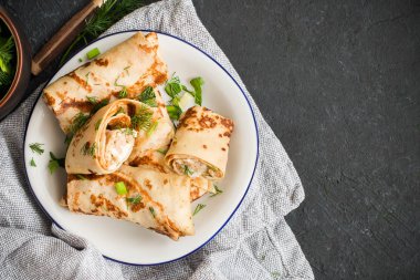 Etli, otlu ve ekşi kremalı krepler - Rus krep haftası Maslenitsa - bahar festivali için geleneksel.