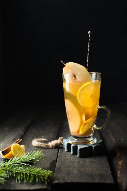 Sıcak baharatlı şenlikli içecek! İle baharatlı armut, zencefil, bal, tarçın ve limon koyu ahşap arka plan üzerinde vintage bir kaşıkla bir bardak beyaz şarap mulled. Kış xmas tatil kavramı.