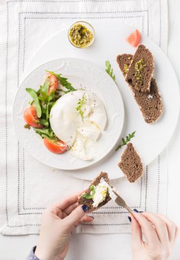 İtalyan peyniri dilimlenir Burrata (mozzarella) taze roka, domates, zeytin yağı, sosu pesto ve tam tahıllı ekmek tost beyaz bir tabak ve ahşap açık renkli. Düz yatıyordu, en iyi görünümü