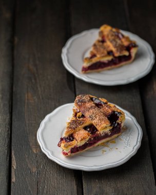 Ahşap arka plan üzerinde beyaz vintage tabakta vişneli pasta bir parça. Uzay kopyalayın. Metin için boş alanı gösterme.