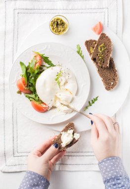 İtalyan peyniri dilimlenir Burrata (mozzarella) taze roka, domates, zeytin yağı, sosu pesto ve tam tahıllı ekmek tost beyaz bir tabak ve ahşap açık renkli. Düz yatıyordu, en iyi görünümü