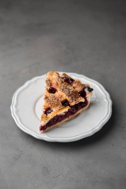 Ahşap arka plan üzerinde beyaz vintage tabakta vişneli pasta bir parça. Uzay kopyalayın. Metin için boş alanı gösterme.