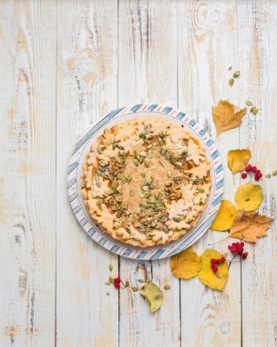 Kabak pasta, sıcak çay, sararmış yapraklar, kitap ve halı ile sonbahar arka plan. Mükemmel güneşli sonbahar. Ahşap açık beyaz sonbahar arka planı sizin için. Uzay kopyalayın. Metin için yer. Düz yatıyordu, en iyi görünümü