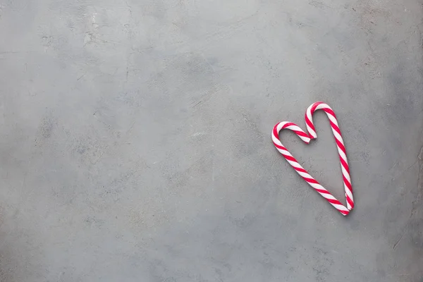 Heart of two candy canes on the gray concrete background. Beautiful background.Flat lay, top view