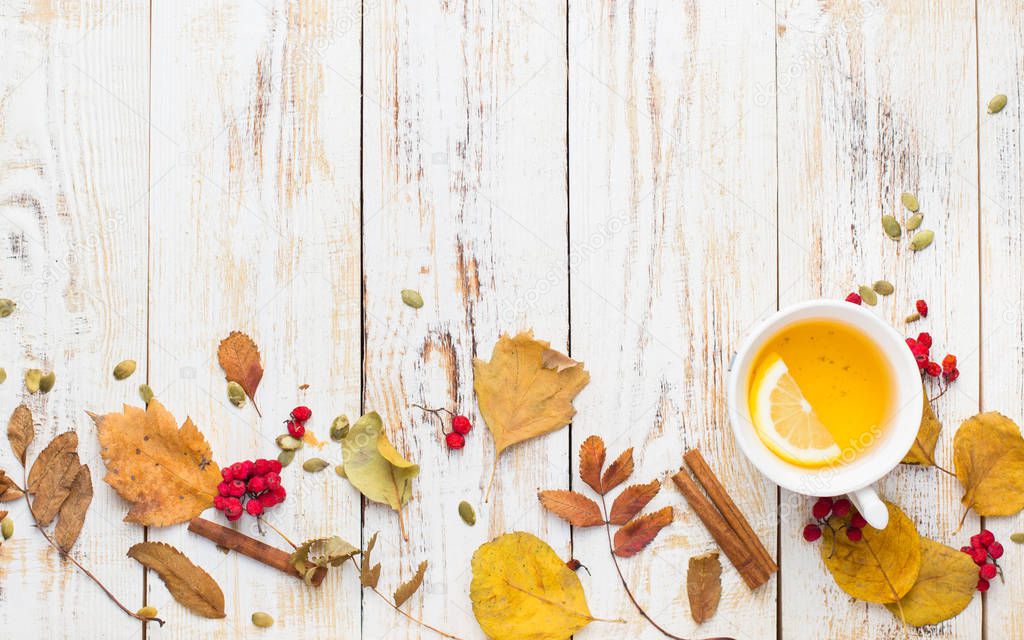Autumn background with pumpkin pie, hot tea, yellowed leaves, book and rug. Perfect sunny autumn. A wooden light white autumn background for you.Copy Space. Place for text. Flat lay, top view