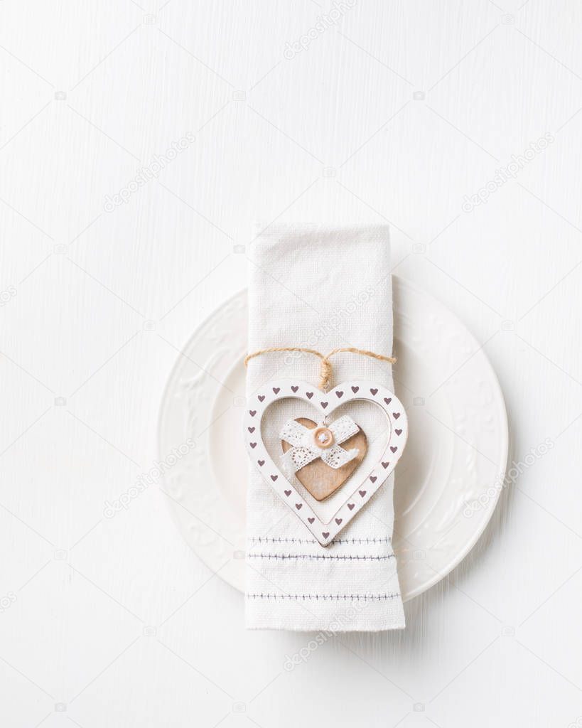 Valentines day (or wedding) meal background with hearts, fork, knife, white napkin. Romantic holiday table setting. Beautiful background with blank. Restaurant concept. Flat lay