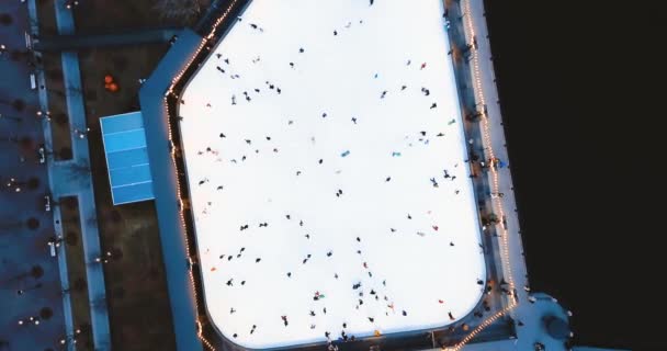 Una pista de patinaje en la calle. La gente cabalga sobre el hielo. New Holland Island en San Petersburgo. Vista superior aérea Panorama 4K para sitio web . — Vídeos de Stock