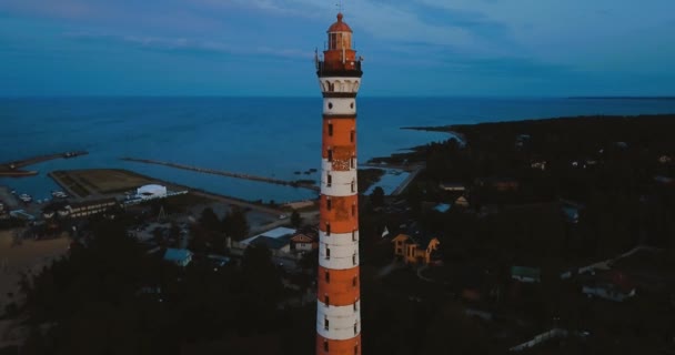 Stara aktywna latarnia. Przygnębiające niebo i zimna niebieska atmosfera. Plaża, północne mgliste morze w stylu skandynawskim. Osinovetsky Światło. Jezioro Ladoga w obwodzie leningradzkim. Widok z lotu ptaka. 4k latanie — Wideo stockowe