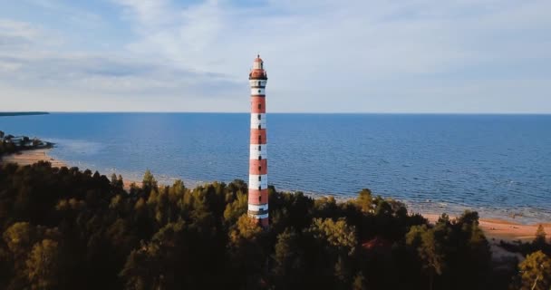 Old active lighthouse. Gloomy sky and cold blue atmosphere. Beach, north misty sea in vintage Scandinavian style. Osinovetsky Light. Lake Ladoga in Leningrad Oblast. Aerial view of seascape. 4K flying — 비디오