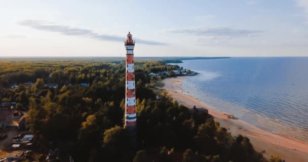 Vecchio faro attivo. Cielo cupo e fredda atmosfera blu. Spiaggia, mare nebbioso nord in stile scandinavo vintage. Luce di Osinovetsky. Lago Ladoga nell'Oblast 'di Leningrado. Veduta aerea del paesaggio marino. 4K in volo — Video Stock