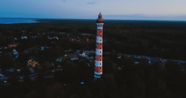 Oude actieve vuurtoren. Een sombere lucht en een koudblauwe atmosfeer. Strand, noordelijke mistige zee in vintage Scandinavische stijl. Osinovetsky Licht. Ladoga meer in Leningrad Oblast. Luchtfoto van zeegezicht. 4k vliegen — Stockvideo