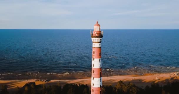Old active lighthouse. Gloomy sky and cold blue atmosphere. Beach, north misty sea in vintage Scandinavian style. Osinovetsky Light. Lake Ladoga in Leningrad Oblast. Aerial view of seascape. 4K flying — 비디오