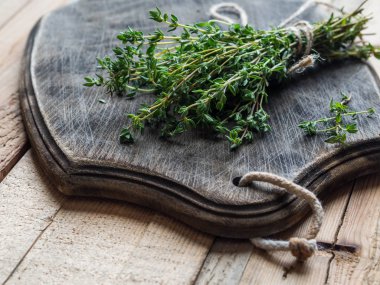 Taze kekik otlar ahşap arka plan üzerinde koyu ekmek gemide bir sürü