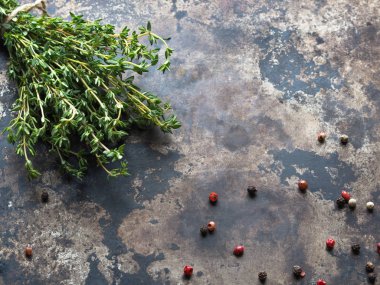 Bir avuç taze kekik ve eski bir metal zemin üzerine baharat