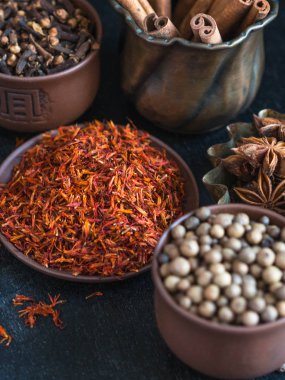 Karanlık bir arka plan üzerine bir kase içinde çeşitli baharatlar