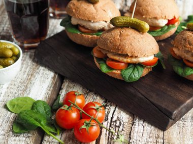 Izgara tavuk, domates ve ıspanak üzerinde rustik bir topuz ile ev yapımı sandviçler  